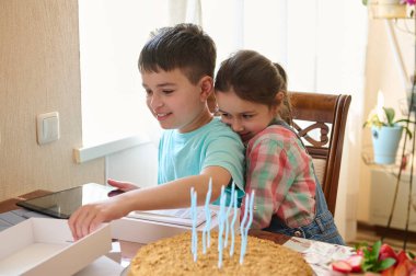 Sevimli küçük kız, içinde mutlu bir sürpriz olan hediye kutusunu açarken ağabeyine sarılıyor ve evde doğum gününü kutluyor. - İnsanlar. Yaşam tarzı. Aile ilişkileri