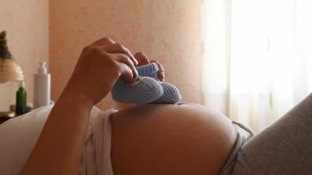 Close Belly Pregnant Woman Expecting Baby Putting Baby Booties Her — Stock Video