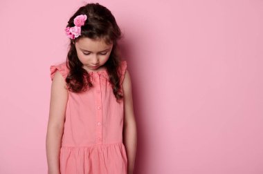 Tatlı bir kız bebek, sevimli beyaz bir piliç, pembe güller saçlarıyla şık elbiseler giyiyor, aşağıya bakıyor, pembe renkli arka planda fotokopi çektiriyor. Çocuklar işte. Mutlu çocukluk