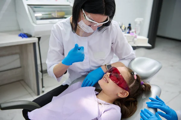 美しい子供の肖像6歳 開いた口を持つ愛らしい少女 歯科衛生士によって検討されています 小児歯科クリニックで歯医者の椅子に座っている間歯科医 歯医者 — ストック写真