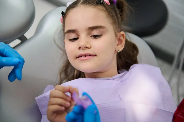 在牙科检查时坐在牙医椅子上的特写小女孩 听牙医如何用牙线清洁牙齿 牙科护理和口腔卫生概念 儿科牙科概念 — 图库照片