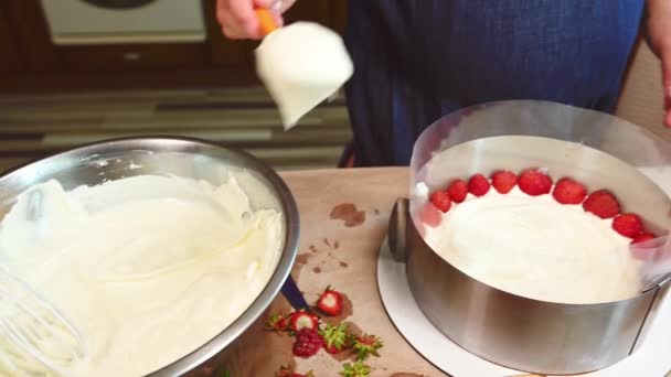 イチゴ夏のムースケーキを作るクローズアップ主婦自宅のキッチンでフライザー 写真だ パン屋さん 伝統的なフランスのパティスリー スポンジケーキに生クリームをのせる — ストック動画