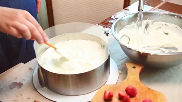 主婦のクローズアップ ホイップクリームを広げたシェフケーキ 取り外し可能な金型の中にムースケーキの最上層を滑らかにし おいしい軽いフランスの夏のデザートを準備するフレイザー — ストック動画