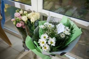 Çiçekçide çeşitli çiçeklerin en üst görüntüsü. Küçük işletme ve çiçekçi dükkanı konsepti. Yakın plan güzel bir buket karışık çiçek ve tebrik kartı. Uzayı kopyala Duvar kağıdı. Çiçek servisi.