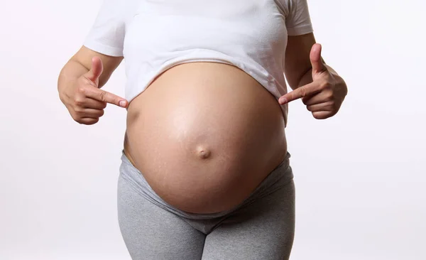 Primer Plano Una Mujer Embarazada Señalando Sus Antepasados Gran Vientre — Foto de Stock