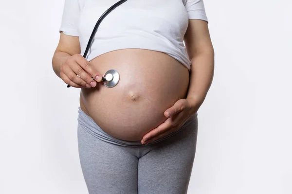 用听诊器给孕妇穿衣 听她未来婴儿的心跳 在怀孕后期摸她的大肚子 产科和妇科 怀孕情况 — 图库照片
