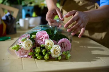 Çiçek tasarım stüdyosundaki taze beyaz ve pembe renunculus buketine odaklan. Çiçek aranjmanları ve hediyeler. Düğün günü. Anneler Günü ve Uluslararası Kadınlar Günü kutlu olsun.
