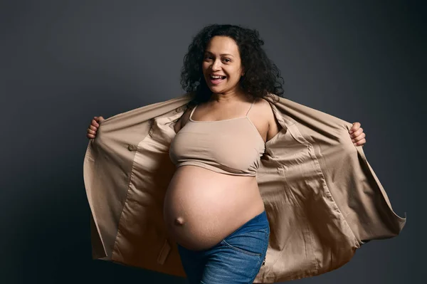 Šťastná Multietnická Kudrnatá Těhotná Žena Módním Béžovém Zákopu Vyčkávající Matka — Stock fotografie