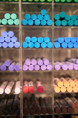 Renkli pastel boya kalemleri ve bir sanat atölyesinde sergilenen kalemlerle dolu bir hayat. Resim yapmak. Çizim yapıyorum. Gölgeleme. Çizim. Yaratıcı hobi ve sanat aletleri. Seçici odaklanma. Yakın çekim.