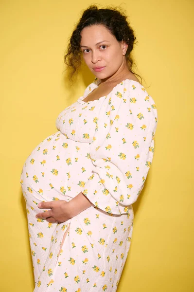 夏の日曜日には 妊娠中のひどい毛髪のエスニック女性が 赤ちゃんを期待して 腹を抱き カメラを見ています マタニティは去っていく 妊娠する 子育てと出産のコンセプト — ストック写真