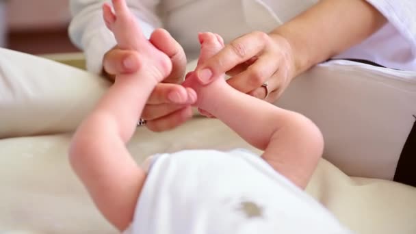 Close Moeders Handen Streelden Zachtjes Voeten Van Haar Pasgeboren Baby — Stockvideo