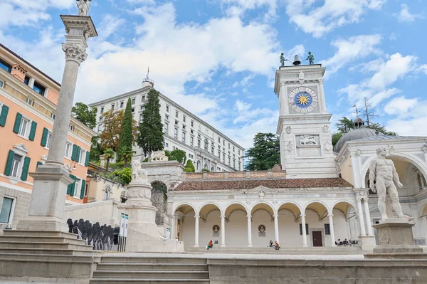 Udine 'deki Liberta Meydanı' nın saat kulesinin yatay fotoğrafçılığı. Colonnade ve Udine Kalesi 'ndeki antik yol. Ağustos 2023 Udine, Friuli Venezia Giulia - İtalya