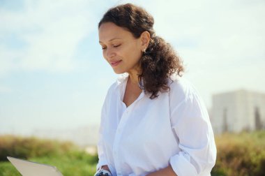 Kendine güvenen, kıvırcık saçlı, serbest çalışan bir kadın girişimcinin yakın plan portresi. Programcı müteahhitler dışarı çıkıyor. - İnsanlar. İnternet işi. Uzak çalışma ve internet iş konsepti