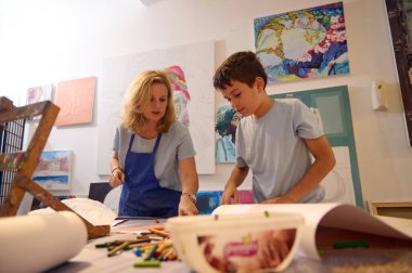 Resim dersi sırasında bir sanat okulu öğrencisi ve kadın ressam öğretmeninin özgün portresi. Sanat sınıfı konsepti. Çizim. Resim yapmak. Güzel ve görsel sanat sınıfı konsepti