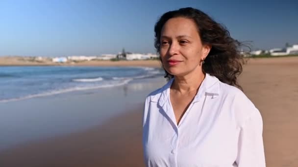 캐주얼 어두운 여성의 초상화 화창한 아름다운 해변에서 산책을 즐기는 대서양 — 비디오