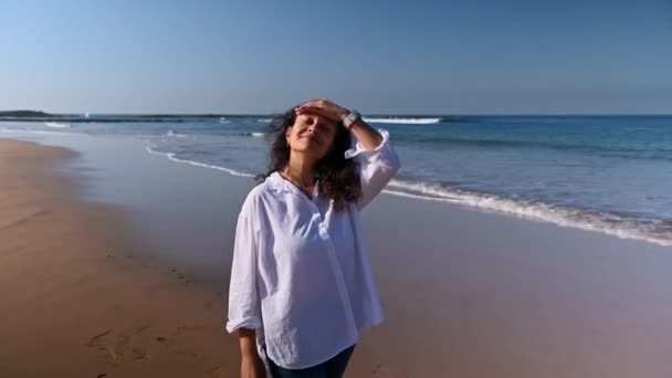 Счастливая Улыбающаяся Женщина Идущая Вдоль Пляжа Волнами Стучащими Песчаному Берегу — стоковое видео