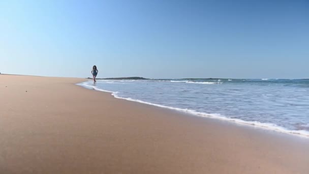 해변을 맨발로 달리는 선드레스를 모래에 발자국을 남겨두고 파도가 그녀가 떠나는 — 비디오
