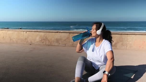 Šťastná Sportovkyně Sluchátkách Pitná Voda Láhve Odpočinek Cvičení Venku Posezení — Stock video