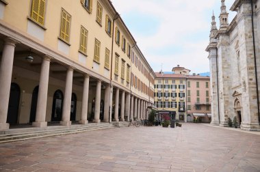 Como, Lombardy, İtalya. İtalya 'nın Como şehrinin merkezinde, Santa Maria Maggiore' un ortaçağ katedralinin girişine yakın sütunları olan boş caddenin fotoğrafları. Güzel mimari