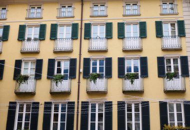 İtalyan mimarisi. Lombardy 'deki İtalyan Como' nun şehir merkezinde çiçeklerle ve bitkilerle süslenmiş güzel balkonları olan bir evin ön cephesi.