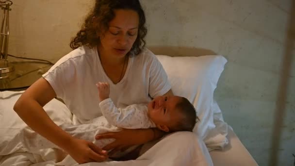 在卧室里 母亲抱在怀里给新生婴儿喂奶的特写 母乳是儿童的天然药物 母乳喂养是降低乳腺癌风险的一种方法 — 图库视频影像