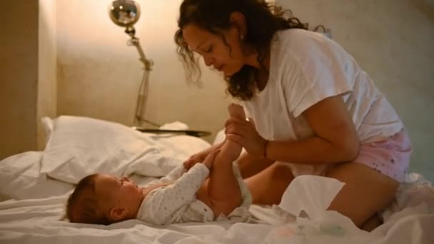 Счастливая Мать Улыбается Меняет Подгузник Маленьком Мальчике Сидя Кровати Уютной — стоковое видео