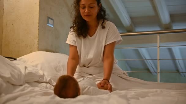 Zwolnij Trochę Latynoamerykańska Kochająca Młoda Matka Siedząca Łóżku Wykonująca Łagodny — Wideo stockowe