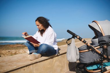 Çok yönlü giyinmiş, plajda kitap okuyan, yeni doğmuş bebeğinin yanında oturan, bebek arabasında uyuyan, hafta sonlarını dışarıda mutlu geçiren çok ırklı bir kadının özgüvenli portresi..