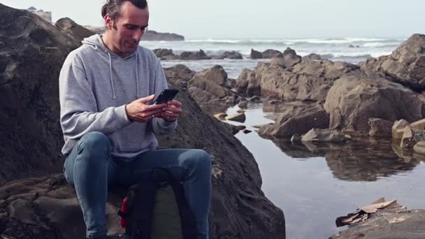 Hombre Adulto Joven Caucásico Relajado Sentado Las Rocas Junto Mar — Vídeo de stock