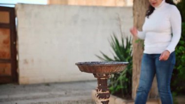 Genç, güzel bir turist, susamış, halka açık bir çeşmeden akan temiz suyu içiyor, İspanya 'nın Jaen ilindeki Endülüs Quesada şehrini ziyaret ediyor.