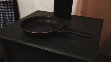 Adamın hamuru kızartma tavasına dökerken, kır evindeki bir odun ocağında krep pişirirken en iyi manzara. Krep pişirme süreci. Shrove Salısı bayramı için geleneksel ziyafet. Yiyecekler. Tatiller
