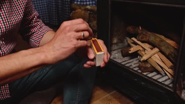 Zbliżenie Człowiek Szachownicy Koszuli Rozpalając Ogień Siedząc Drewnianej Podłodze Przy — Wideo stockowe