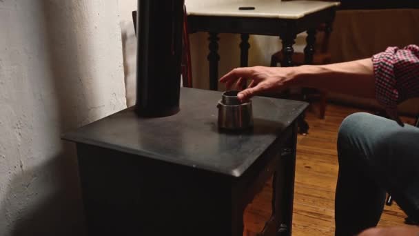 田舎の家で薪焼きストーブでエスプレッソコーヒーを作るクローズアップ男性 — ストック動画