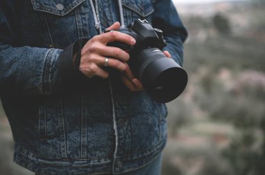 Profesyonel kamera, erkek gezgin fotoğrafçının elinde. - İnsanlar. Seyahat et. Turizm ve modern dijital teknoloji