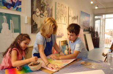 Yaratıcı görsel sanatlar atölyesinde resim öğreten, resim dersi sırasında çocuklara resim yapmayı öğreten, güzel öğrencilerle tavsiye ve becerilerini paylaşan ilham verici bir kadın. Yaratıcılık ve hayal gücünü geliştir. Eğitim