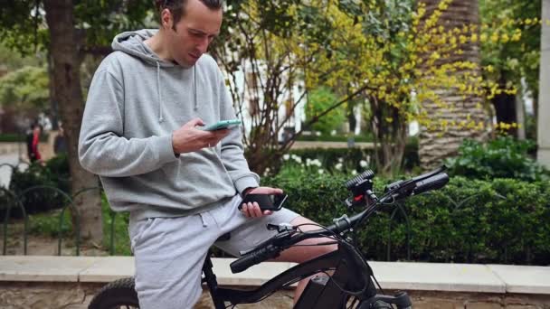 Pemuda Hipster Dewasa Yang Menyewa Sepeda Listrik Menggunakan Aplikasi Sewa — Stok Video