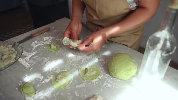 女人们用土豆泥填饱绿色面团的特写镜头 用配料站在厨房桌旁形成饺子 烹调华而不实的过程中的一步一步 传统的乌克兰餐 — 图库视频影像