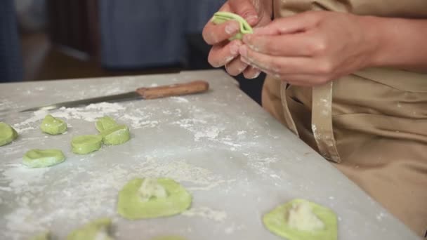 여자의 요리사의 베이지 앞치마에 시금치 반죽을 소시지를 만들고 반죽을 롤아웃 — 비디오