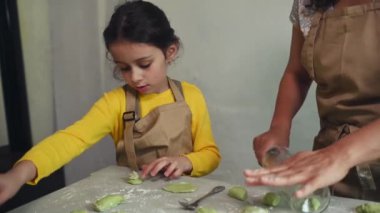 Mutlu anne ve kız kırsal bir evin kırsal kesiminde hamur köftesi pişiriyorlar. Küçük kız Ukrayna usulü Varennyky ya da İtalyan mantısı yapmayı öğreniyor. - İnsanlar. Mutfak. Mutfak.
