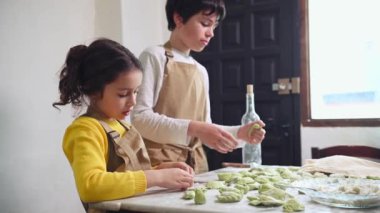 Bej şefin önlüklerini takmış, hamurlu mermileri dolduruyor, kırsal kesimin mutfağında hamur köftesi yapıyorlar. Sevimli okul çocukları yemek hazırlıyor, evde aşçılık öğreniyorlar.