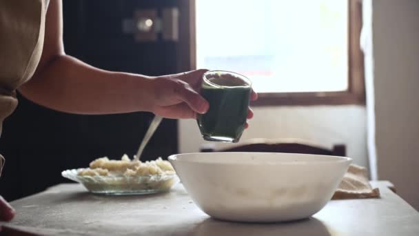 家庭主妇的密切合作 主厨糕点将绿色菠菜水倒入一个装有小麦四只的碗里 在乡村的家厨房里 用绿色的面团和土豆泥包饺子 — 图库视频影像