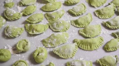 Üst Manzara. Küflenmiş çiğ hamur köfteleri ile yemek geçmişi. Varennyky ve ravioli, mutfak masasının un kaplı mermer yüzeyinde. Ukrayna geleneksel mutfağı. Yiyecekler. Gelenekler ve kültür