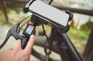 Yakın çekim bisikletçi dışarıda elektrikli bisiklet sürerken dijital ekranda programı ayarlıyor. Model ekran ile düzeltilmiş akıllı telefon. Cep telefonu ya da kira uygulaması için reklam alanı kopyala. - İnsanlar. Teknoloji. Eko taşımacılığı.