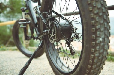 Yol kenarında duran, borusuz elektrikli bisiklet tekerleğinin ayrıntıları. Aşağıdan bak. Düşük görüş açısı. Seçici odak