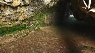 Küçük dağ nehrinde kristal berrak su. Küçük şelaleli yabani sarmaşıklarla kaplanmış bir mağaradaki hızlı akarsu. Tam üstte. Dağlarda şelale. La Sierra de Cazorla. Sabit çekim