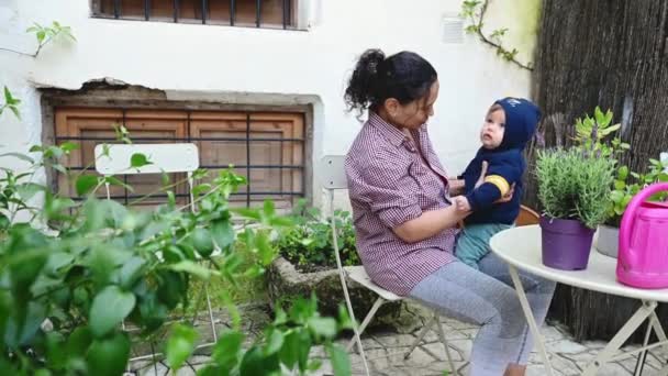幸せな若い女性 愛する母親は 彼女の赤ちゃんの男の子と遊んで テーブルに座ってラベンダーの植物を精査し それを嗅ぎ 子供の頃から愛を教育する植物を学びます — ストック動画