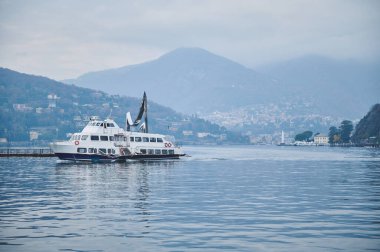 Dağlarla çevrili bir gölde huzur içinde süzülen bir yolcu gemisi ve göl kenti. Huzurlu manzara sakinliği ve rahatlığı çağrıştırıyor..
