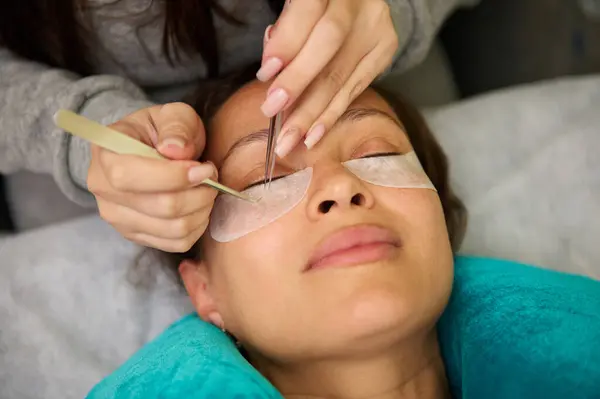 stock image A close-up of a woman enjoying an eyelash extension procedure in a beauty salon. Calm and relaxation during professional beauty treatment.