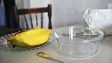 Bardak karıştırma kabının yanındaki tabakta taze mango dilimi. Yemek pişirme, sağlıklı yaşam ve kırsal mutfak ortamları için mükemmel..