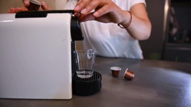 Bir kadın kahve makinesiyle kendine espresso kahve yapıyor.. 